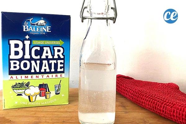 Une bouteille en verre avec un carton de bicarbonate à côté 
