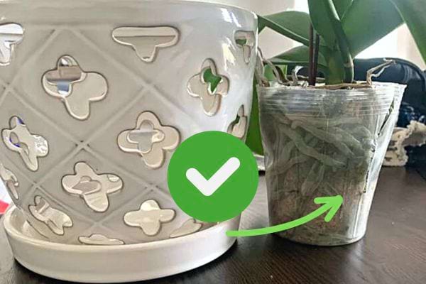 Un cache pot blanc à côté d'un pot d'Orchidée