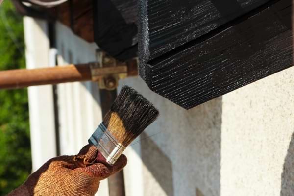 Une couche de produit hydrofuge passée au pinceau sur un toit pour prévenir la mousse