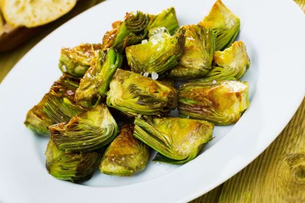 Plusieurs feuilles d'artichaut dans une assiette blanche 