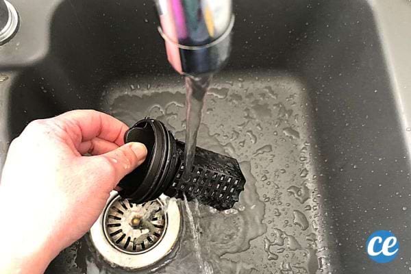 Un filtre de machine à laver sous l'eau dans un évier