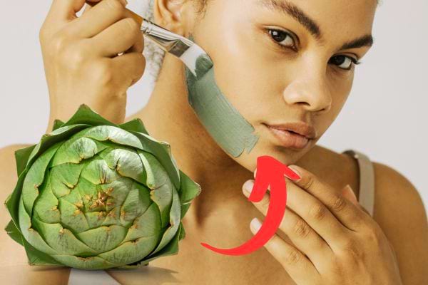 Une femme qui met un masque vert à base de feuilles d'artichaut sur son viage à l'aide d'un pinceau 