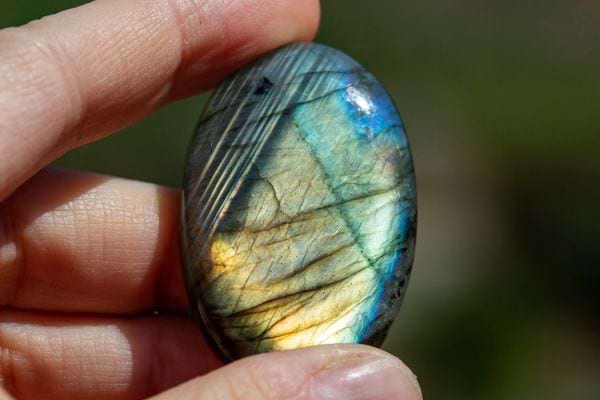 Une personne tenant une pierre Labradorite
