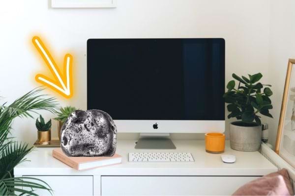 Une pierre Shungite sur un bureau avec un ordinateur