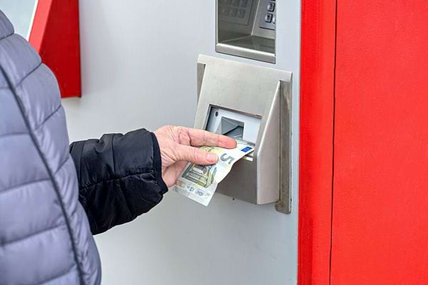 Une personne qui retire de l'argent d'un distributeur automatique 