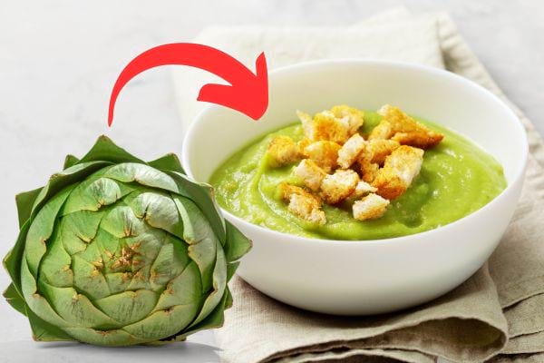 Un bol blanc contenant une soupe à base de feuilles d'artichaut avec des croûtons 