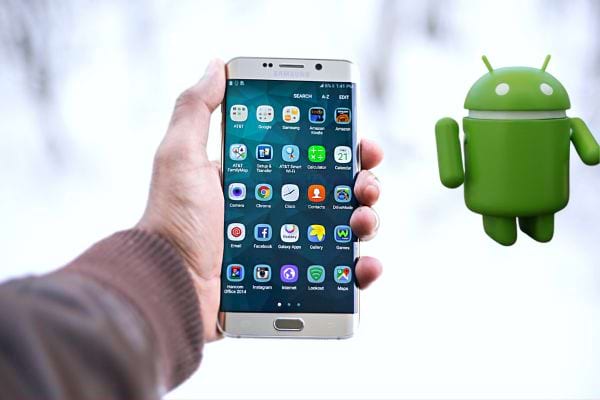 Une personne tenant un Samsung dans sa main gauche