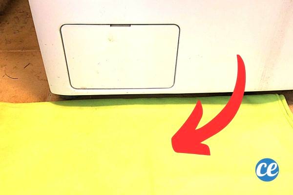 Un tissus jaune en face du cache filtre de la machine à laver