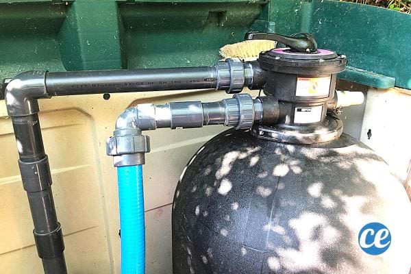 Une grosse pompe noire avec deux gros tuyaux noir et bleu