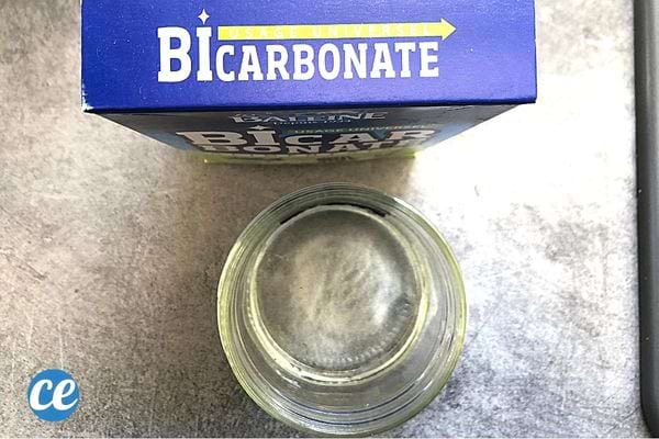 Un verre avec un carton de bicarbonate juste derrière 