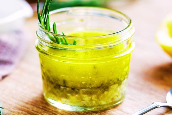 Une coupelle en verre avec de la vinaigrette aromatisée à l'intérieur 