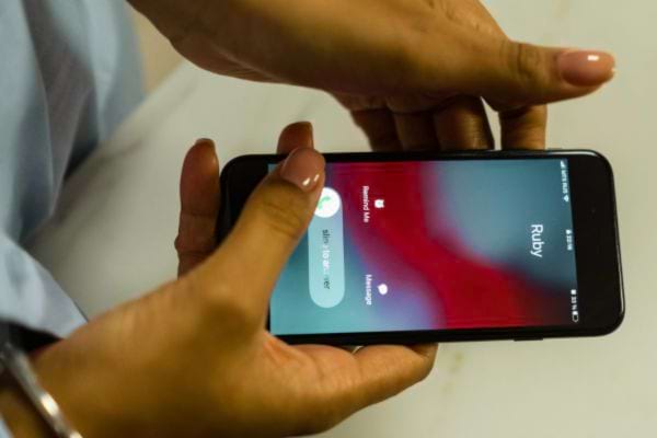 Une femme tenant un iPhone recevant un appel dans ses mains