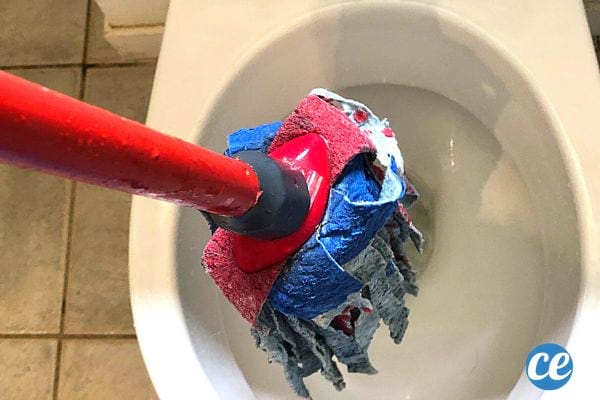 Un balai à franges au dessus des toilettes