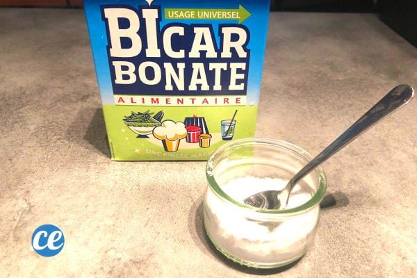 Un carton de bicarbonate avec un récipient contenant du bicarbonate et cuillère à café à l'intérieur