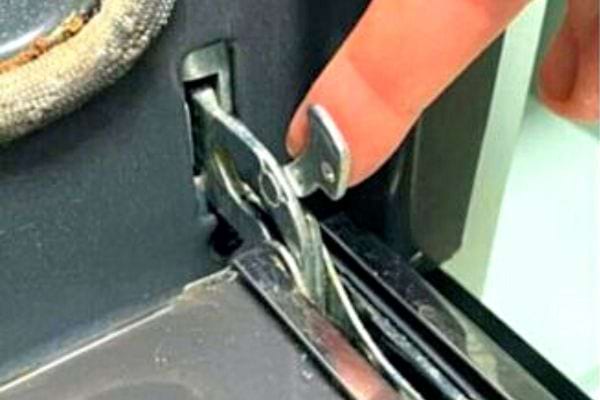 Une personne mettant son index sur le bouton d'une porte de four 