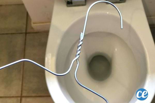 Un cintre en métal au dessus des toilettes 