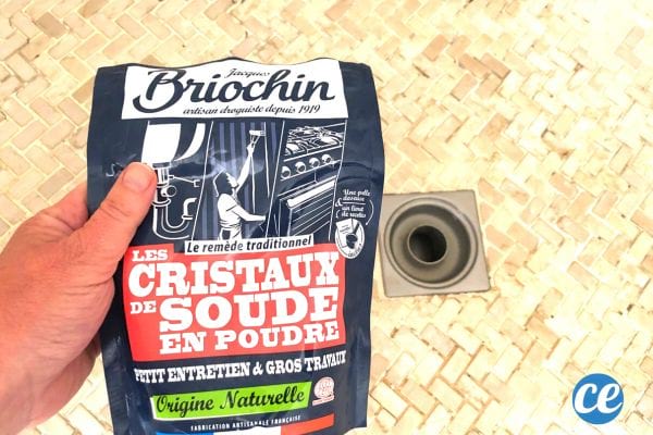 Une personne tenant des cristaux de soude dans une douche