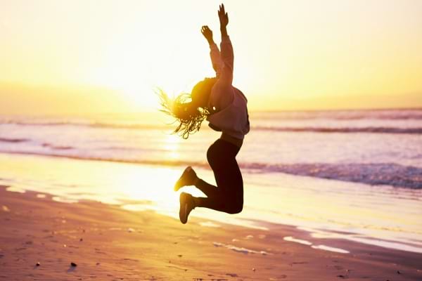 Une femme qui saute sur la page car elle est épanouie grâce à la pyramide de Maslow