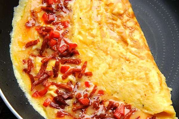 Une omelette au chorizo avec sa variante aux pommes de terre dans une poêle