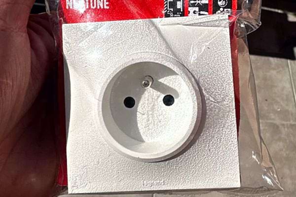 Une personne tenant une prise de terre dans un petit sachet transparent