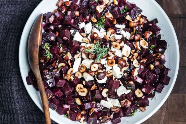 Une assiette blanche de salade de betteraves au chèvre