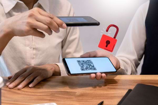 Une personne scanant un QR code sur le smartphone d'une autre personne 