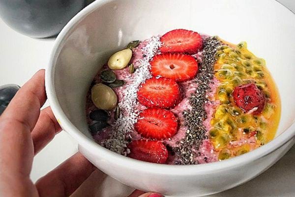 Une personne tenant un smoothie bowl