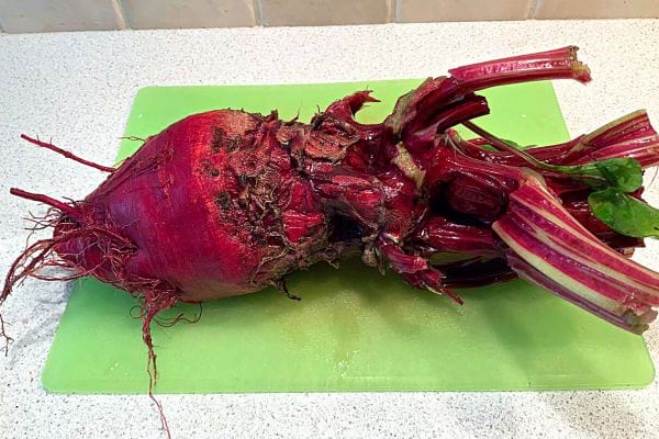 A beetroot on a green cutting board 