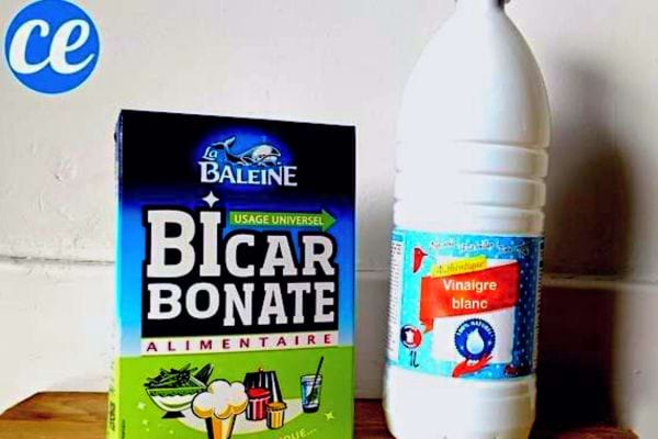 Du bicarbonate de soude à côté d'une bouteille de vinaigre blanc
