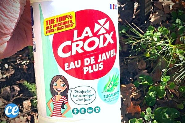 Une personne tenant une bouteille d'eau de javel