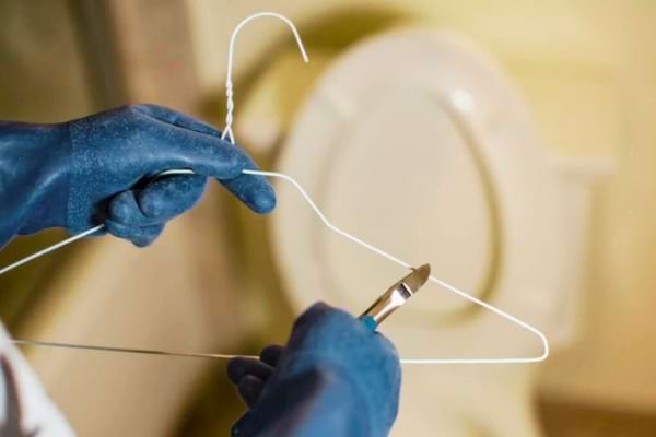 Un cintre qui permet de déboucher un wc sanibroyeur