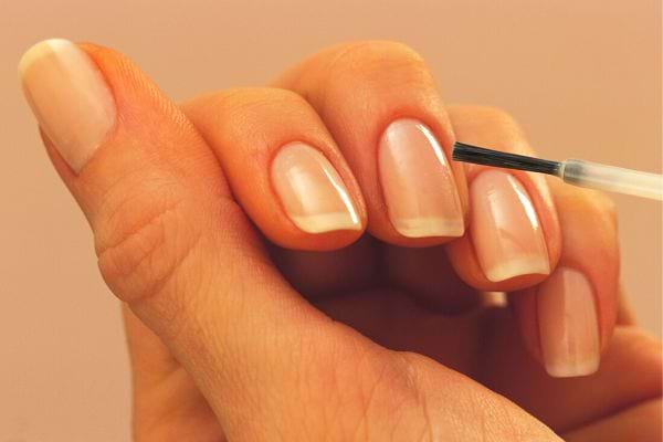 une personne se met du vernis à ongles