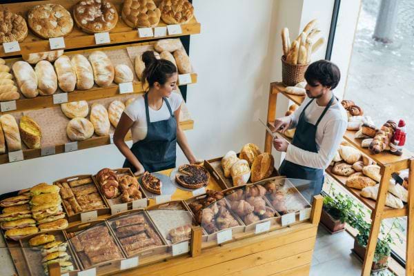 Deux employés en tablier dans une boulangerie