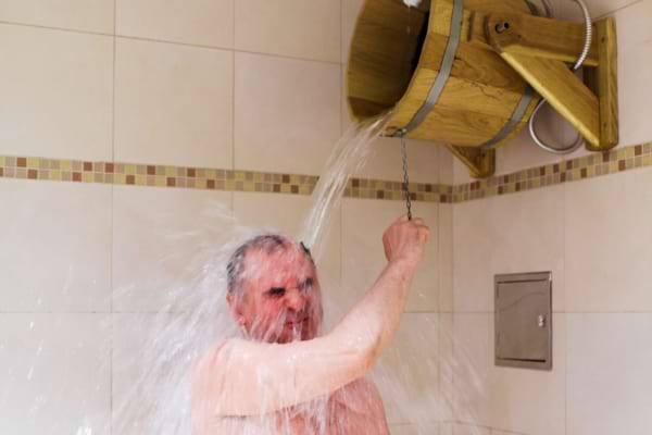 Un homme qui fait une douche à l'eau froide pour soigner ses oedèmes