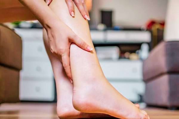 Une femme faisant un massage avec des huiles essentielles pour réduire les oedèmes