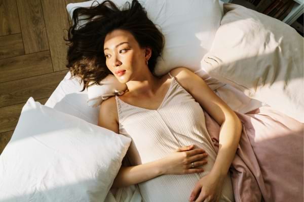 Une femme couchée sur un lit qui réfléchit sur l'abstinence sexuelle