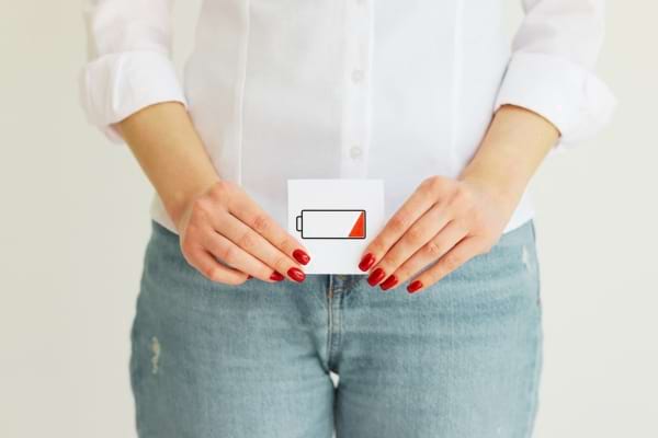 Une femme tenant un petit carton traduisant une baisse de libido