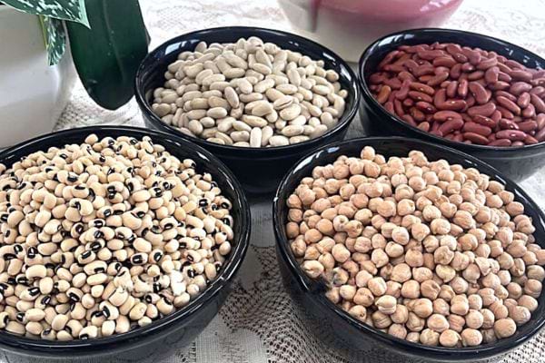 Quatre bols noirs contenant des légumes secs 