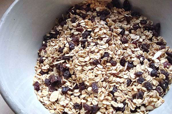 Un bol blanc remplie de muesli et de raisins secs 
