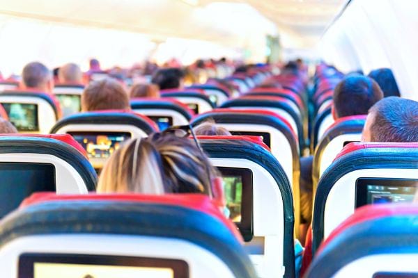 Plusieurs personnes de dos assises dans un avion