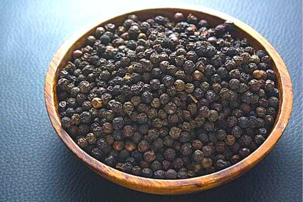 Du poivre en gros morceaux dans un petit bol marron 