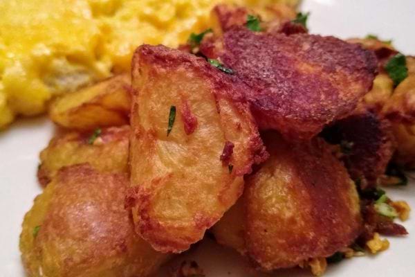 Des pommes de terre avec une omelette dans une assiette blanche