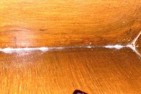 A wooden piece of furniture containing dust 