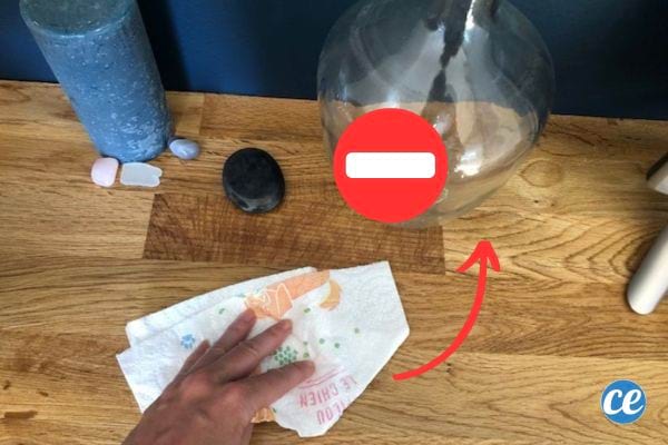 Une personne tenant un sopalin dans sa main sur un meuble en bois