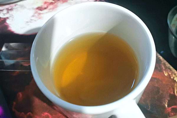 Une tasse blanche contenant de la tisane 