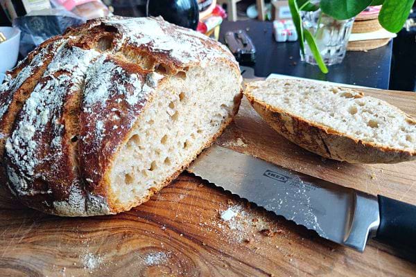 Du pain découpé sur une planche en bois avec un gros couteau IKEA