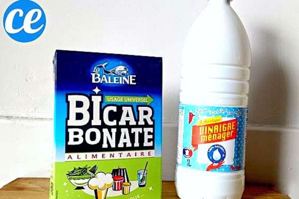 Un paquet de bicarbonate de soude et une bouteille de vinaigre ménager à côté