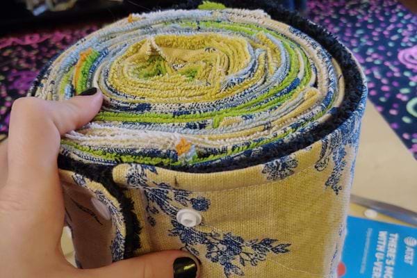 Une personne tenant un boudin de porte isolant avec plusieurs torchons 