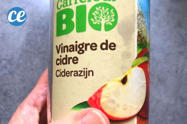 Une personne tenant une bouteille de vinaigre de cidre
