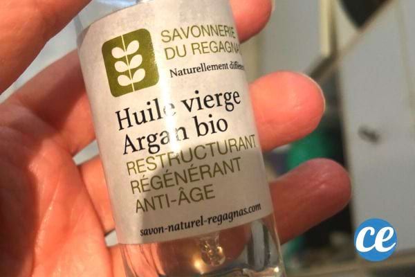 Une personne tenant une bouteille vide d'huile vierge d'argan bio